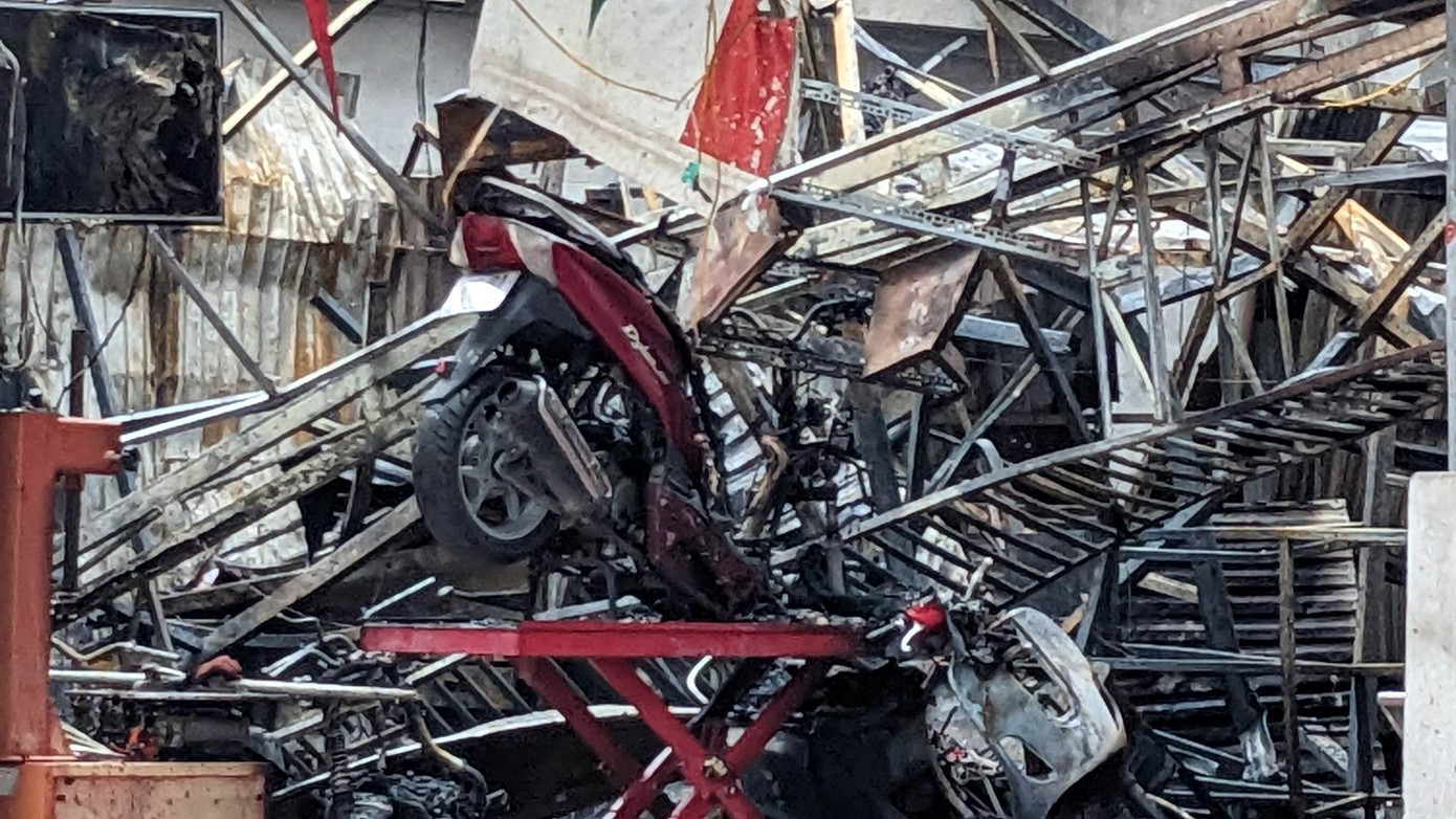 Chiếc xe máy nằm lẫn trong đống sắt thép.