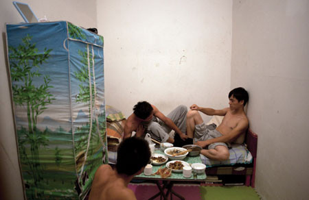 Ren Liang, 22 tuổi, (quay lưng) ăn bữa tối tự nấu trong căn phòng ngầm cùng hai người bạn tới thăm ở Bắc Kinh, 24-8-2011. Ước tính 1 triệu dân nhập cư sống trong các tầng hầm và hầm trú bom tại thủ đô của Trung Quốc