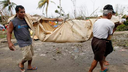 ... và ở thành phố Tacloban. Ảnh: Sky Cư dân mang thi thể của một người thân thiệt mạng sau bão