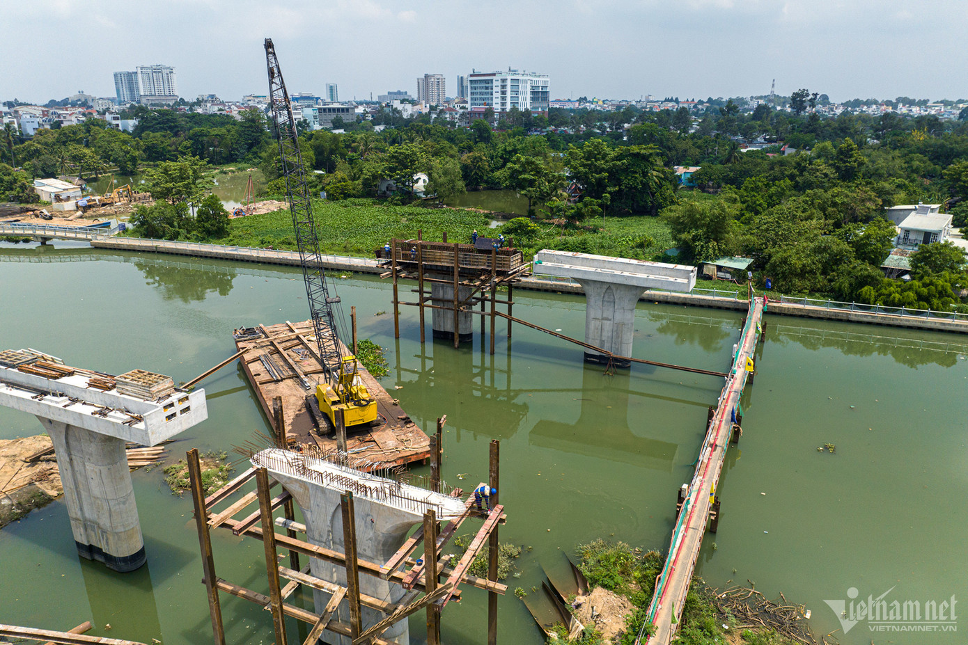 Tại vị trí hai đầu cầu Thống Nhất, việc giải phóng được mặt bằng vẫn chưa xong, máy móc không tiếp cận được vị trí thi công. Nguyên vật liệu phải vận chuyển bằng đường sông. Hàng trăm mét ống được lắp đặt để bơm bê tông đã gây khó khăn và phát sinh thêm nhiều chi phí cho nhà thầu.