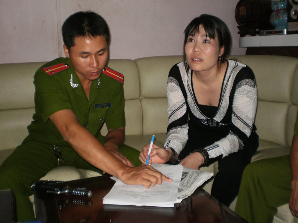 Nguyễn Thị Trâm, bị còng tay phải ký vào biên bản xử lý.