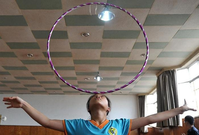Một học sinh của trường Cao đẳng nghệ thuật Xiếc Đài loan đang tập luyện với chiếc vòng tại tỉnh Yunnan (Trung Quốc)