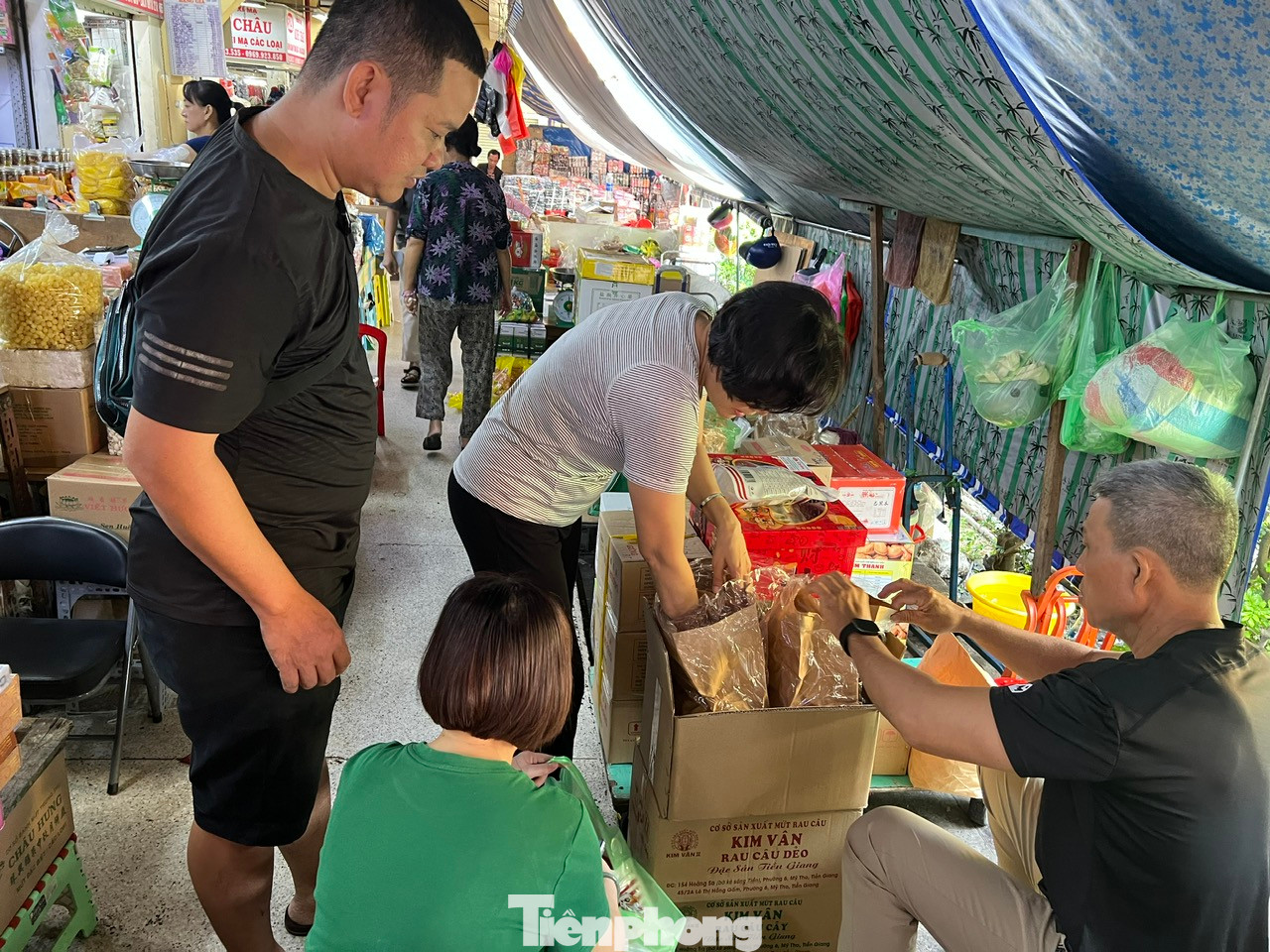 Tiểu thương liên tục khui những thùng hàng mới để châm lên quầy sạp. "Cách đây khoảng một tuần, khách đến mua sắm vẫn còn thưa thớt thì nay đã nhộn nhịp hơn. Đặc biệt nhiều đoàn khách du lịch từ nước ngoài đến tham quan cũng mua sắm. Chúng tôi tranh thủ bán trong khoảng 3 ngày cao điểm Tết, đến 29 tháng Chạp là dọn dẹp, đóng quầy để đón Tết" - chị Hiền, tiểu thương kinh doanh thực phẩm khô chia sẻ. Tiểu thương liên tục khui những thùng hàng mới để châm lên quầy sạp. "Cách đây khoảng một tuần, khách đến mua sắm vẫn còn thưa thớt thì nay đã nhộn nhịp hơn. Đặc biệt nhiều đoàn khách du lịch từ nước ngoài đến tham quan cũng mua sắm. Chúng tôi tranh thủ bán trong khoảng 3 ngày cao điểm Tết, đến 29 tháng Chạp là dọn dẹp, đóng quầy để đón Tết" - chị Hiền, tiểu thương kinh doanh thực phẩm khô chia sẻ.