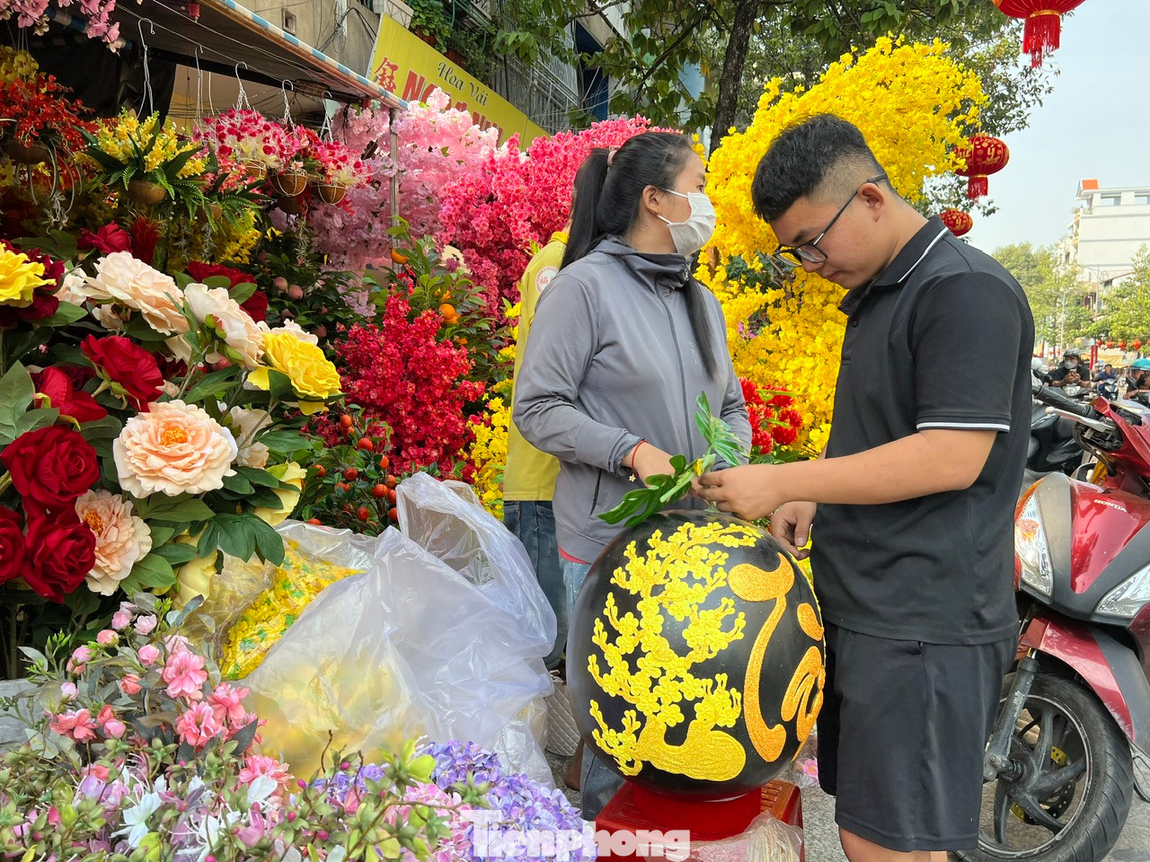 Một tiệm hoa giả chào mời khách hàng một quả dưa hấu khổng lồ được chạm khắc tỉ mỉ cành mai và các câu đối chúc Tết. Đặc biệt chữ Tài được viết kiểu thư pháp, nạm kim tuyến nổi bật. Một tiệm hoa giả chào mời khách hàng một quả dưa hấu khổng lồ được chạm khắc tỉ mỉ cành mai và các câu đối chúc Tết. Đặc biệt chữ Tài được viết kiểu thư pháp, nạm kim tuyến nổi bật.