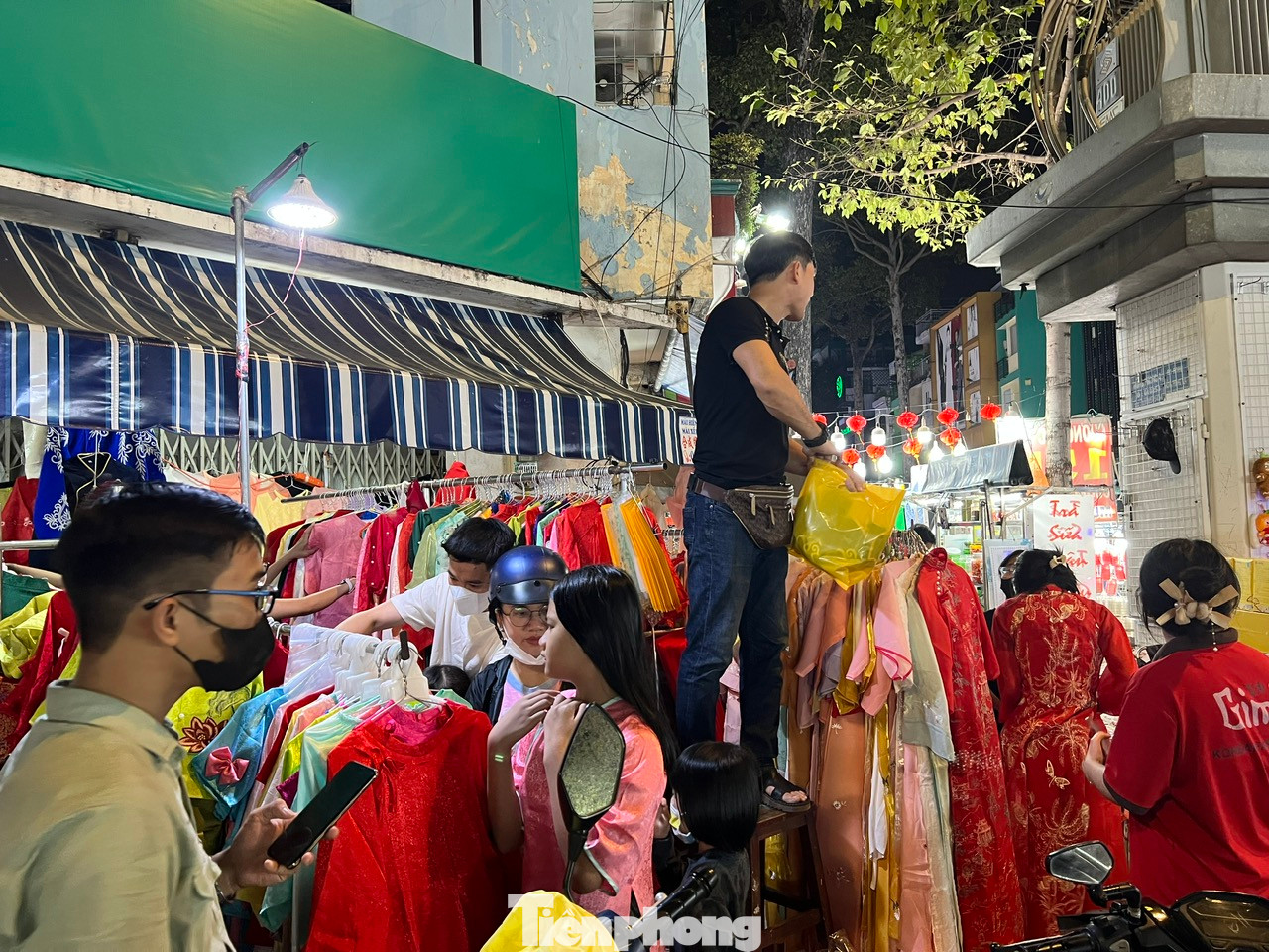 Một quầy hàng kinh doanh áo dài hiếm hoi có nhiều khách đến xem và chọn mua. Giá áo dài ở đây rất "mềm", chỉ từ 350.000 - 650.000 đồng/bộ. Khách mua 2 - 3 bộ còn được giảm giá thêm.