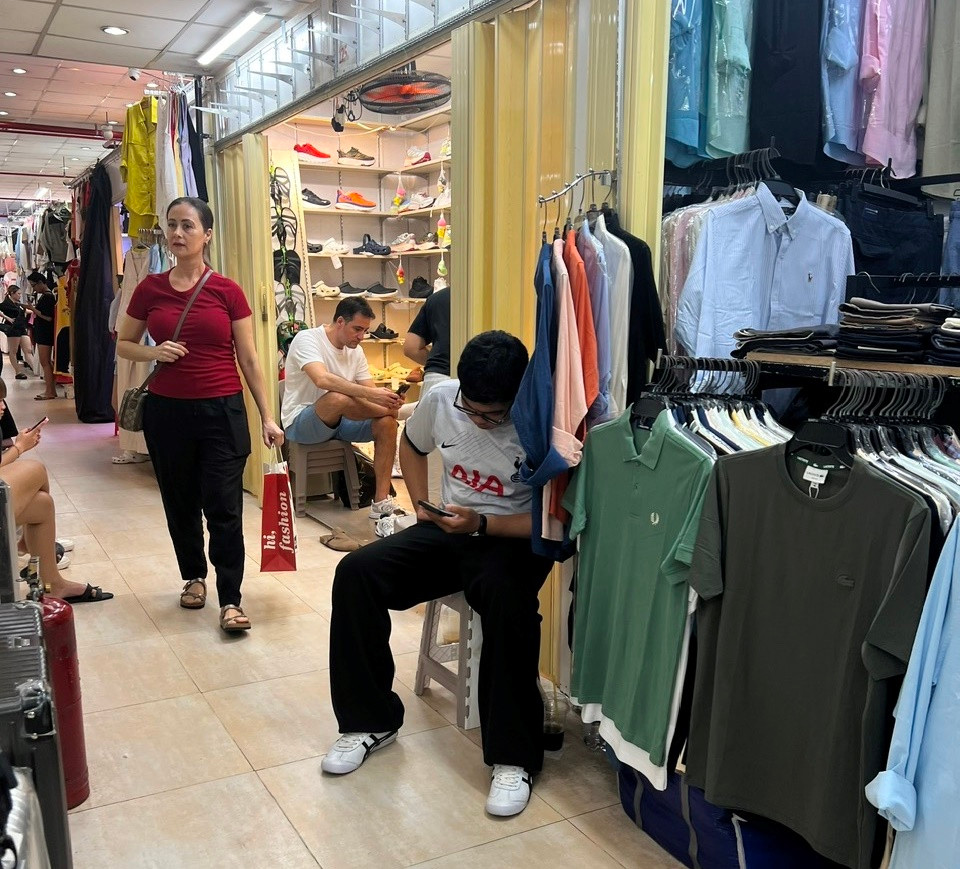 Nơi còn kinh doanh buôn bán thì chỉ mở cửa he hé, nhân viên người bên trong, kẻ bên ngoài quầy sạp để đón khách Nơi còn kinh doanh buôn bán thì chỉ mở cửa he hé, nhân viên người bên trong, kẻ bên ngoài quầy sạp để đón khách