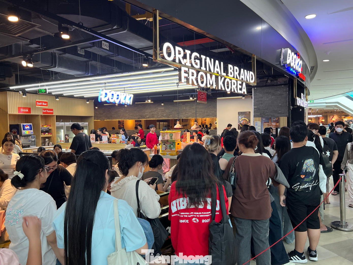 Một quán ăn Hàn Quốc còn chăng dây để khách xếp hàng. "Tôi đi cùng nhóm bạn và đã chờ đợi hơn 30 phút rồi nhưng vẫn chưa có chỗ. Khách càng lúc càng đông. Chúng tôi dự định sẽ vui chơi ở trung tâm thương mại cả ngày, sau khi ăn thì sẽ xem phim, mua sắm. Tuy nhiên nếu phải chờ đợi quá lâu, có lẽ chúng tôi sẽ tìm một quán khác" - chị Trang Nhã (ngụ quận 11) chia sẻ.