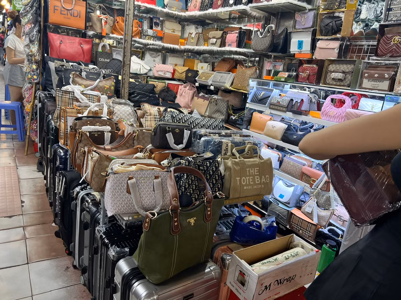 Nhiều loại ví, túi xách "hàng hiệu" bày bán tại chợ Bến Thành, giá chỉ vài trăm nghìn đồng/sản phẩm
