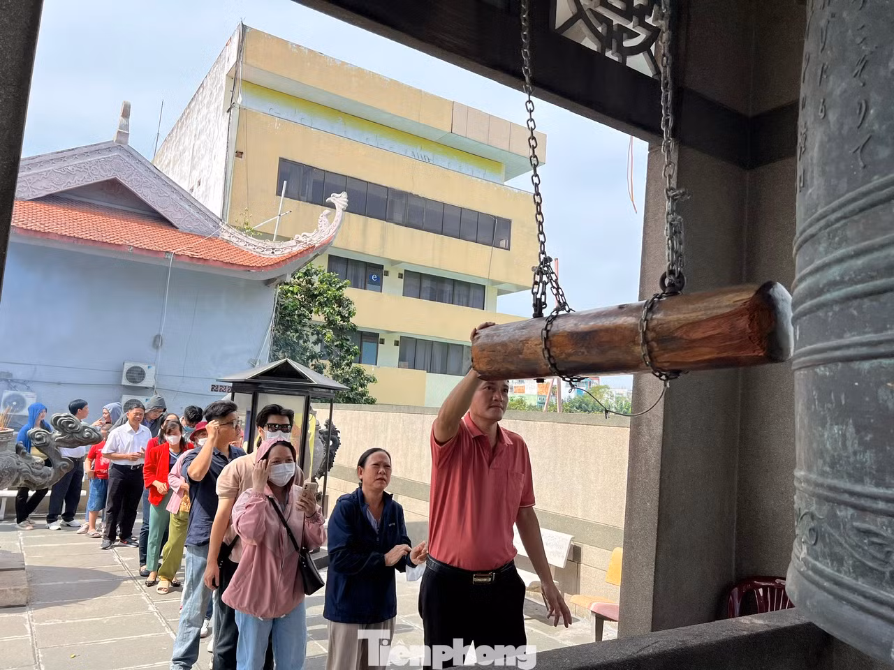 Tại chùa Vĩnh Nghiêm (quận 3), hàng trăm người đội nắng xếp hàng chờ đến lượt tự tay gõ vang 3 tiếng chuông.