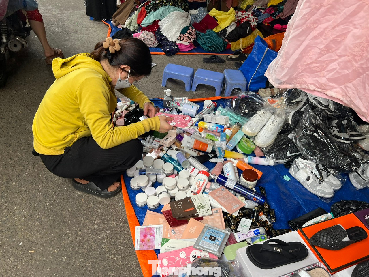 Ngày 2/6, tại chợ Bàn Cờ (quận 3, TPHCM) nhộn nhịp mua bán với đủ các mặt hàng thời trang, mỹ phẩm mang các thương hiệu trong nước và quốc tế được đổ đống dưới đất, giá chỉ vài chục nghìn đồng/sản phẩm, tha hồ cho khách thử hàng và chọn mua.