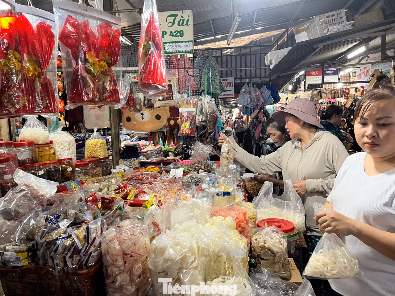 Quầy hàng bánh mứt may mắn có một khách mua, hai chủ sạp liền nhanh tay phục vụ. Quầy hàng bánh mứt may mắn có một khách mua, hai chủ sạp liền nhanh tay phục vụ.
