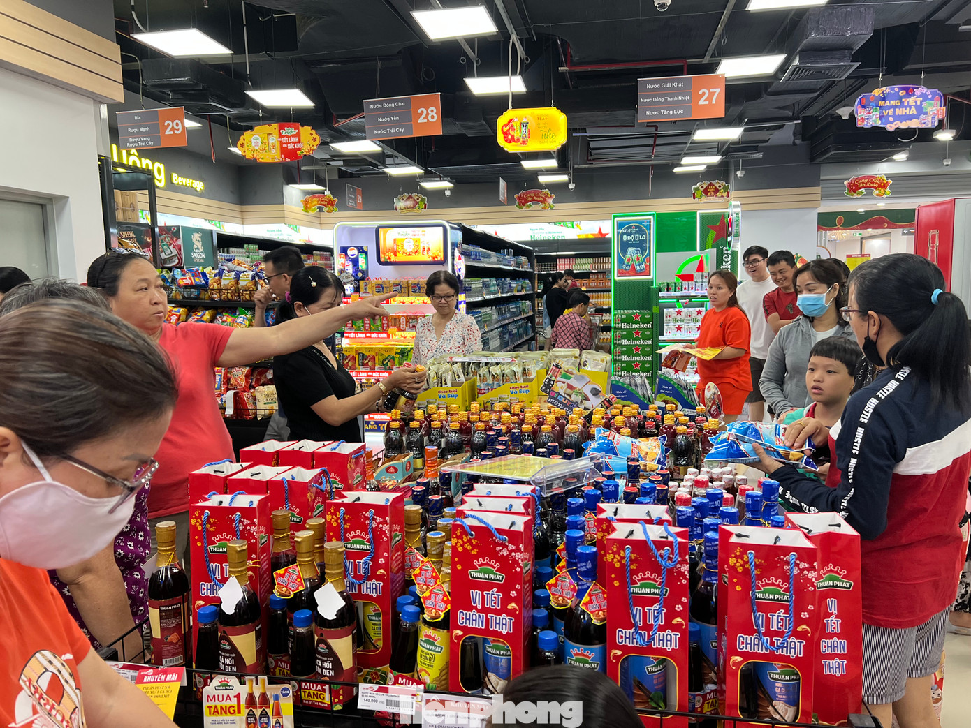 Khách hàng liên tục tham khảo giá, lấy hàng cho vào xe đẩy. "Sản phẩm nào cũng mua 1 tặng 1 nên tôi sắm nhiều để dành ăn Tết. Mình tranh thủ sắm Tết sớm để có nhiều lựa chọn. Năm nay các siêu thị khuyến mãi nhiều nên tôi yên tâm hơn" - chị Ngọc (ngụ quận Tân Phú, TPHCM) nói.