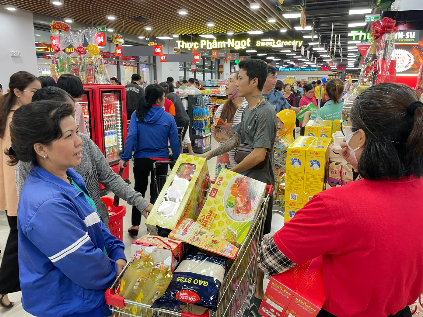 Hàng loạt mặt hàng như dầu ăn, xúc xích, nước khoáng, bánh mứt, hạt điều, mì gói... đều mua 1 tặng 1. Miến cua 129.000 đồng/thùng áp dụng mua 1 tặng 1 nên các bà nội trợ đua nhau thu gom