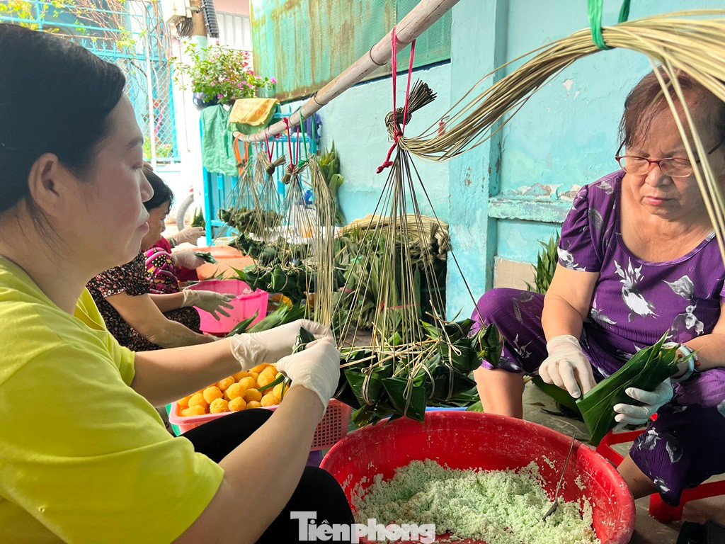 Một ngày trước Tết Đoan Ngọ, xóm bánh ú lá tre quận 8 dường như khẩn trương, nhộn nhịp hơn. Người gói bánh ngồi tụm nhau, đôi tay thoăn thoắt xếp từng lá tre vào nhau, sau đó cho nếp đã ngâm mềm cùng với viên nhân đậu vo tròn vào bên trong và cột chặt bằng dây lạt.