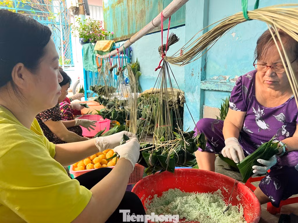 Một ngày trước Tết Đoan Ngọ, xóm bánh ú lá tre quận 8 dường như khẩn trương, nhộn nhịp hơn. Người gói bánh ngồi tụm nhau, đôi tay thoăn thoắt xếp từng lá tre vào nhau, sau đó cho nếp đã ngâm mềm cùng với viên nhân đậu vo tròn vào bên trong và cột chặt bằng dây lạt.