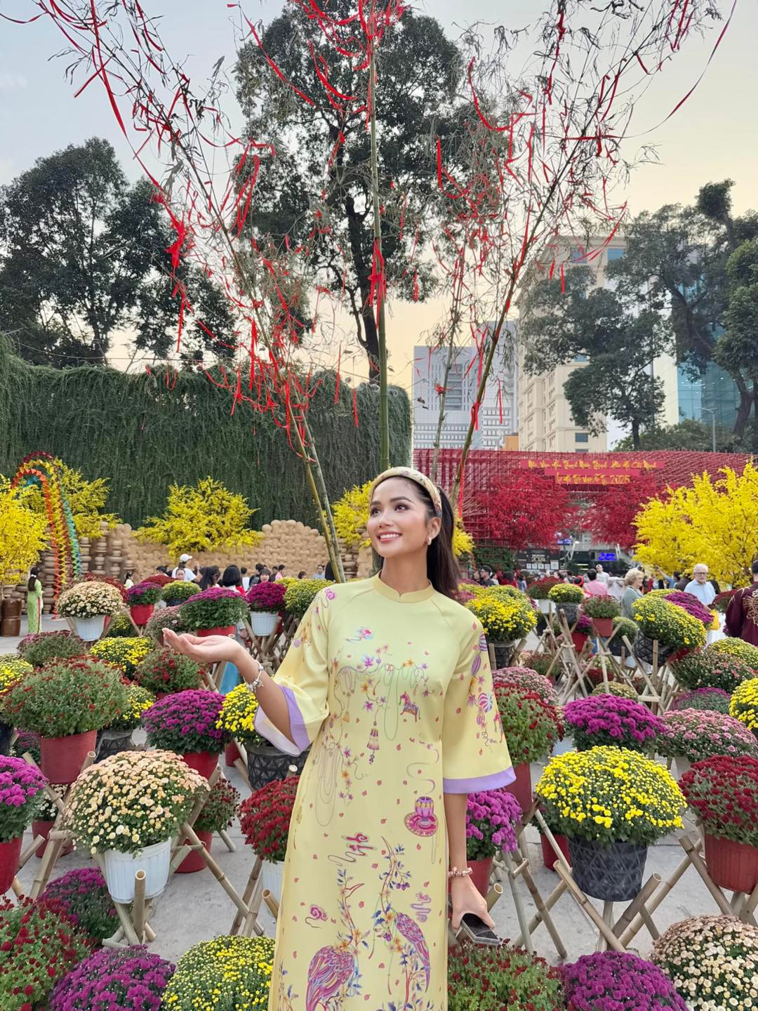 Hoa hậu H'Hen Niê khoe sắc với áo dài ở hội chợ xuân.