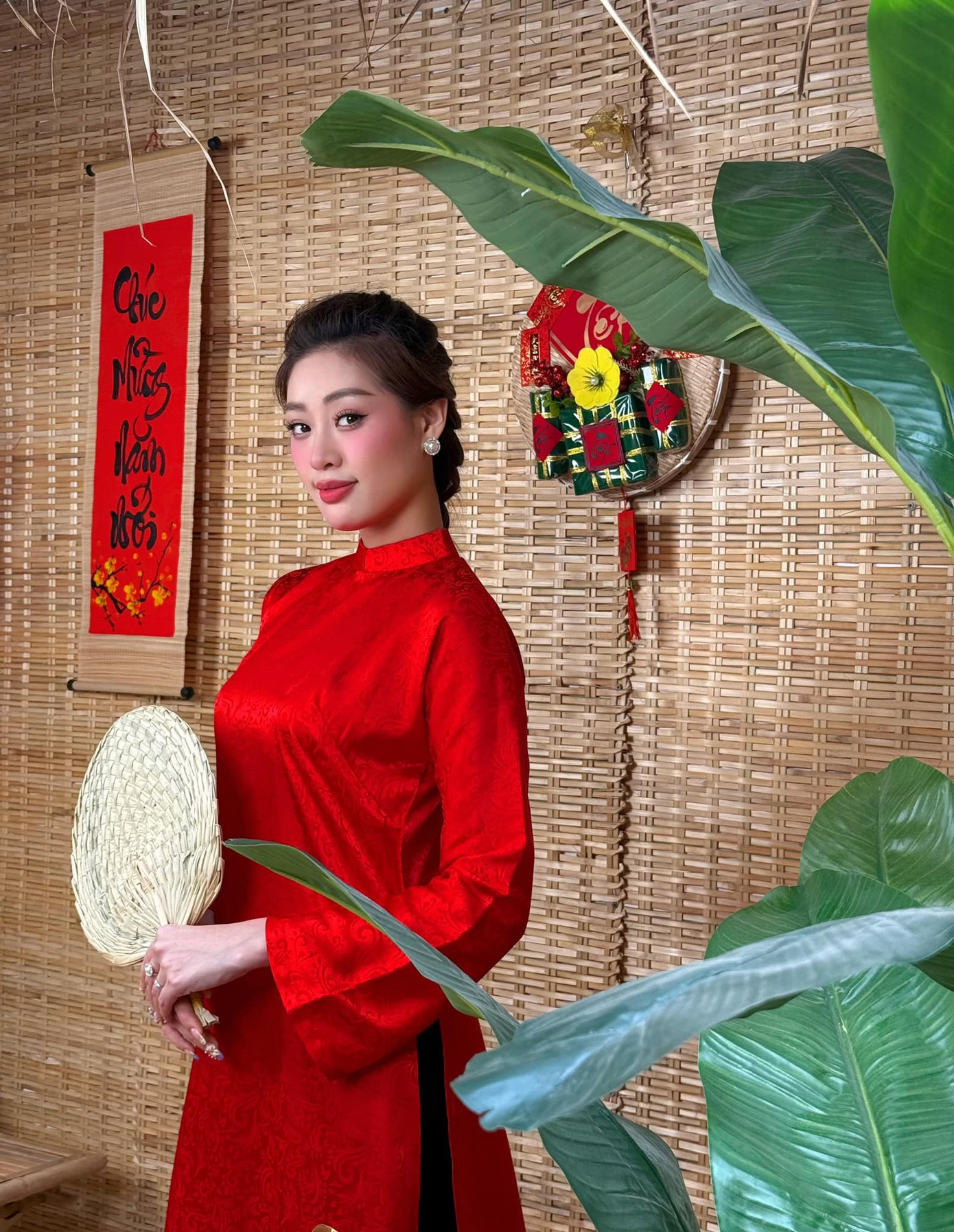 Hoa hậu Khánh Vân chọn áo dài cổ tròn với tông màu đỏ nổi bật khi đi chợ xuân.