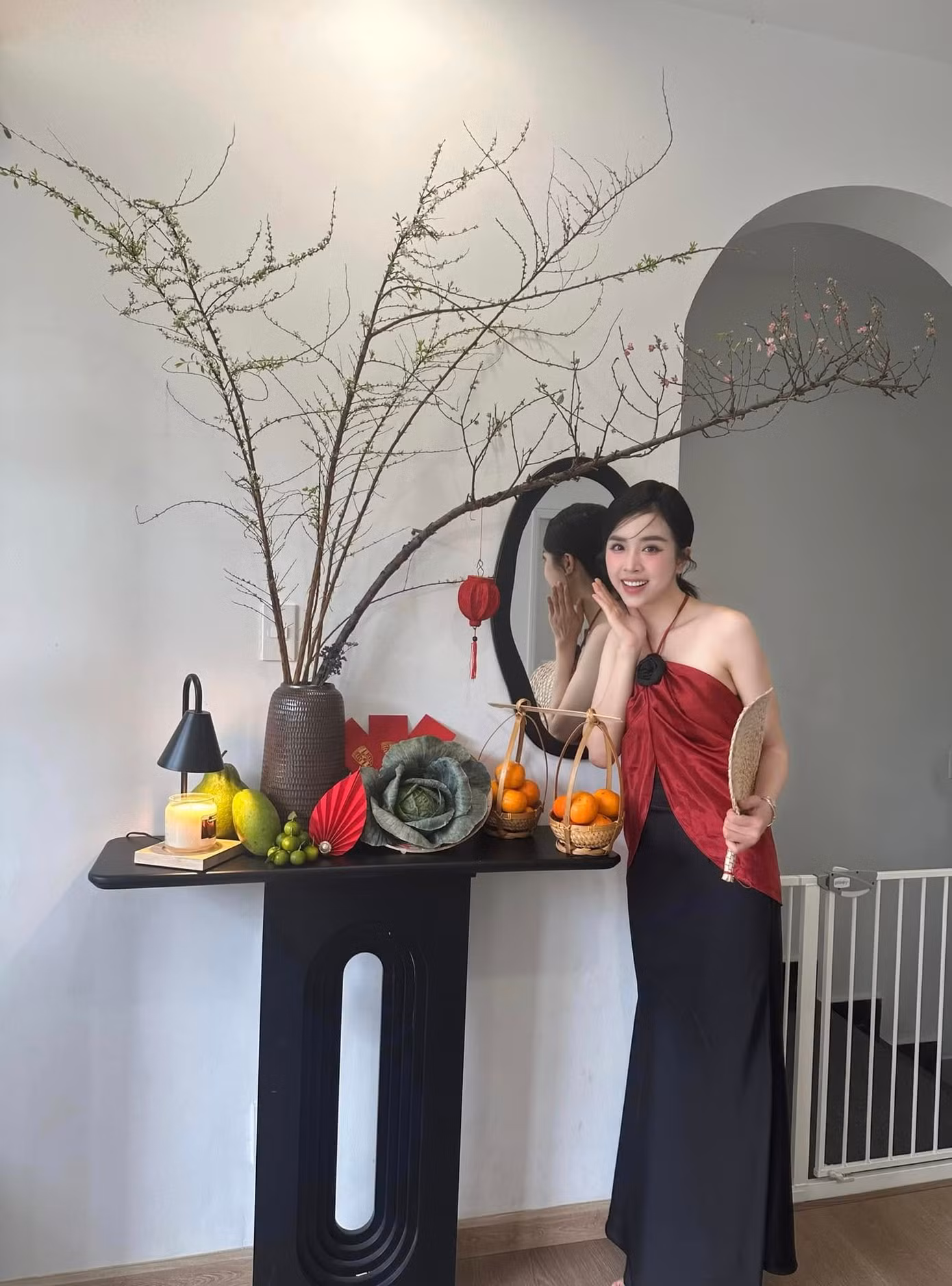 Á hậu Thúy An mặc váy kiểu cổ yếm, khoe vai trần khi chuẩn bị đón Giao thừa. Người đẹp trang trí nhiều góc decor mang đậm không khí Tết trong nhà.