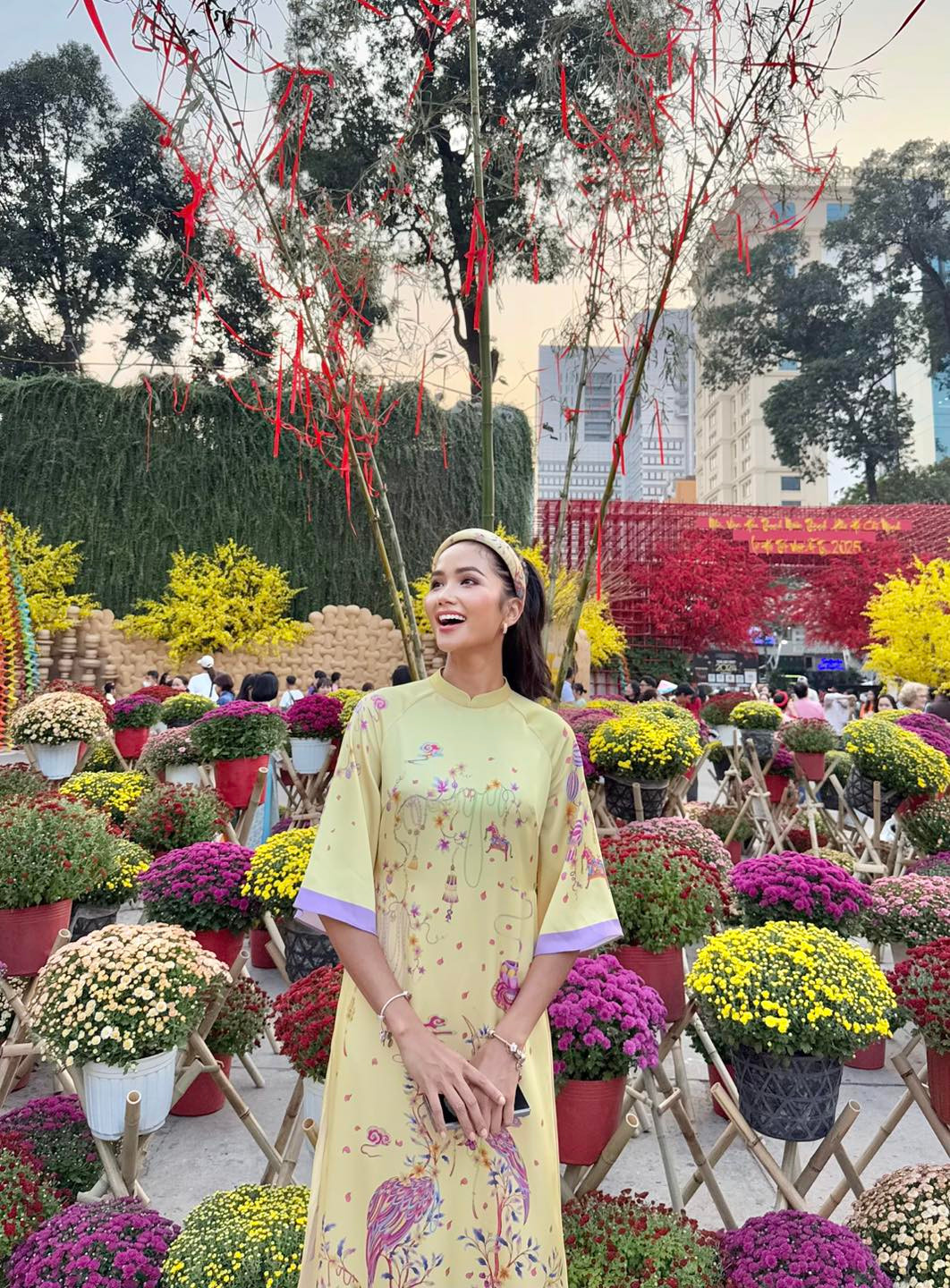 Hoa hậu H'Hen Niê khoe sắc với áo dài ở hội chợ xuân.