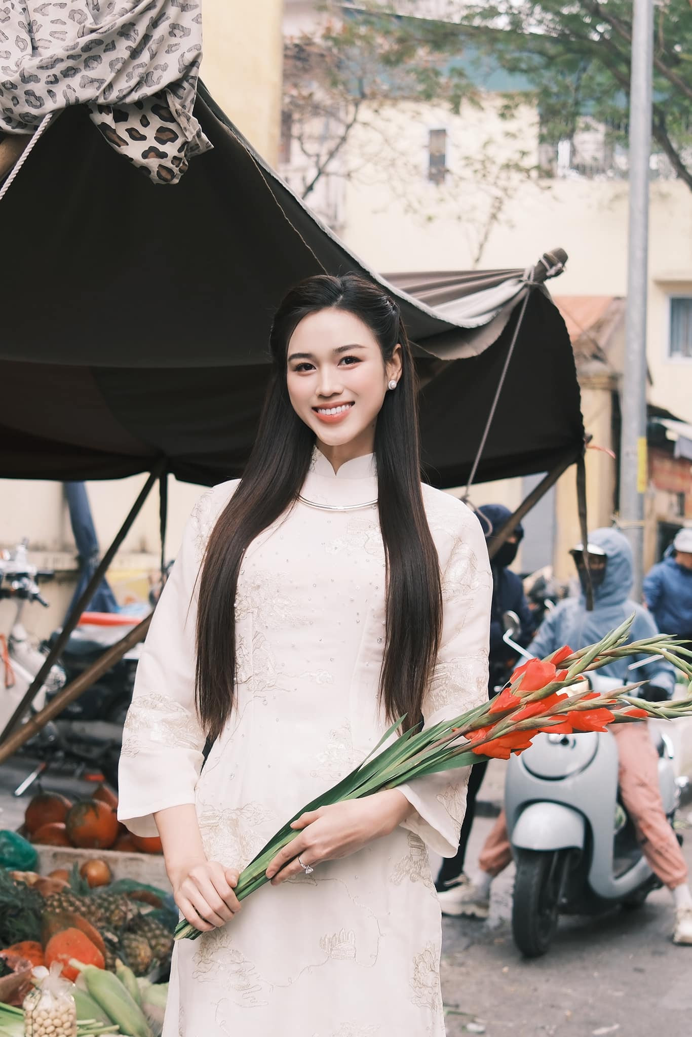 Hoa hậu Đỗ Thị Hà diện áo dài trắng họa tiết đi chợ Xuân những ngày cận Tết. Cô mặc áo dài lụa, kiểu dáng suông, tông màu nền nã.