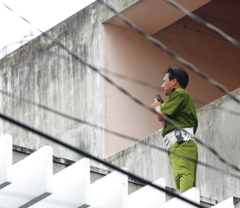 Lực lượng CA đang tiến hành vây bắt hai hung thủ trên nóc nhà cao tầng - ảnh T.H.V