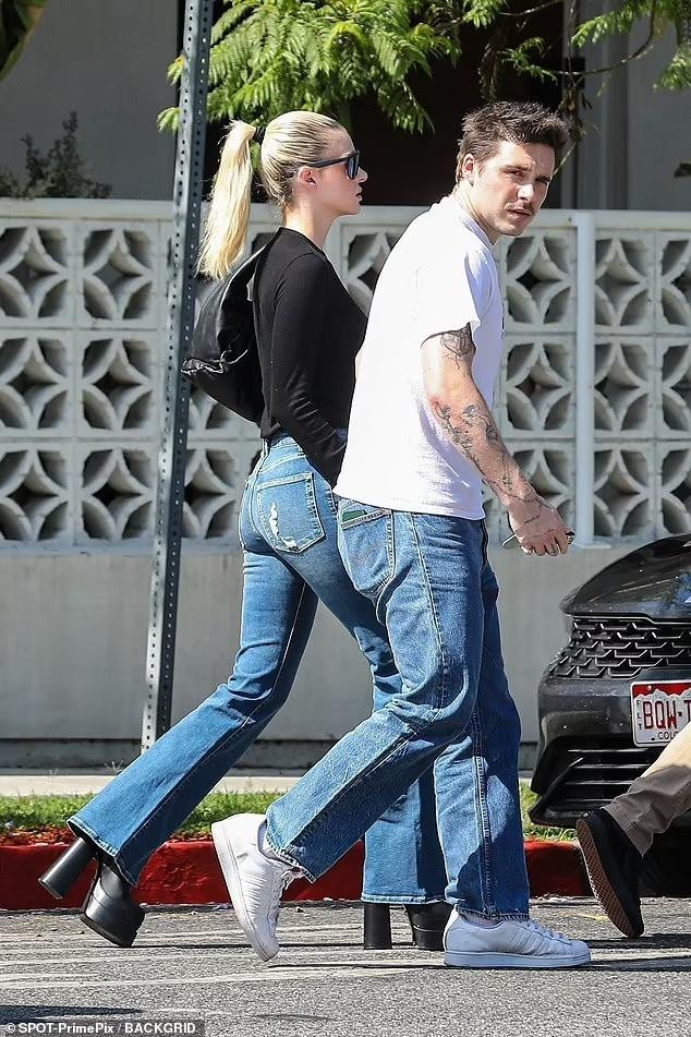 Nữ diễn viên &quot;Bates Motel&quot; trông sang chảnh, kiêu kỳ với áo đen dài tay bó, quần jean ống loe kết hợp kính râm, boot cao gót và túi xách đồng bộ. Brooklyn giản dị hơn trong bộ đồ áo phông trắng, quần jean và giày thể thao.