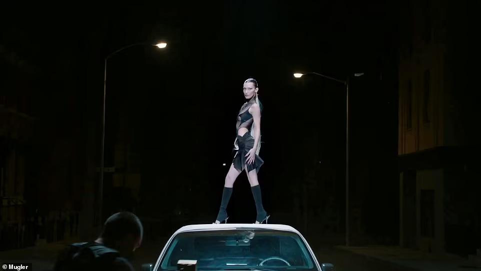 Với tông đen và nude chủ đạo, Bella xuất hiện trên nóc chiếc limousine trong chiếc váy xuyên thấu tạo bạo.