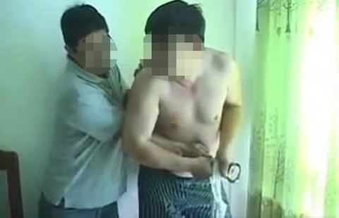 Một người đàn ông cầm còng số 8 khống chế ông Vương (Ảnh cắt từ clip)