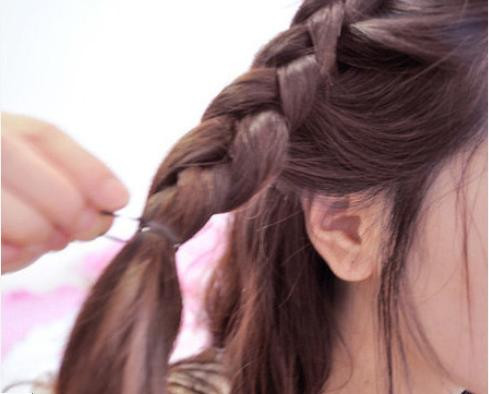 Rẽ phần lệch sang một bên Tết từ trước ra sau, đến đỉnh đầu thì tết ngang sang một bên và cố định lại Ở bên đối diện bạn cũng tết một lọn tóc từ trên đỉnh đầu xuống. Phần đuôi tóc bạn dùng máy uốn xoăn lên để tạo độ phồng cho tóc.