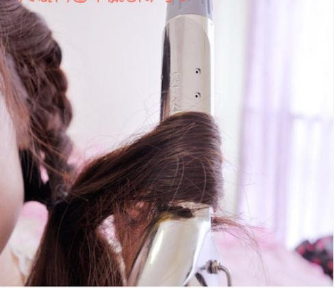 Rẽ phần lệch sang một bên Tết từ trước ra sau, đến đỉnh đầu thì tết ngang sang một bên và cố định lại Ở bên đối diện bạn cũng tết một lọn tóc từ trên đỉnh đầu xuống. Phần đuôi tóc bạn dùng máy uốn xoăn lên để tạo độ phồng cho tóc.