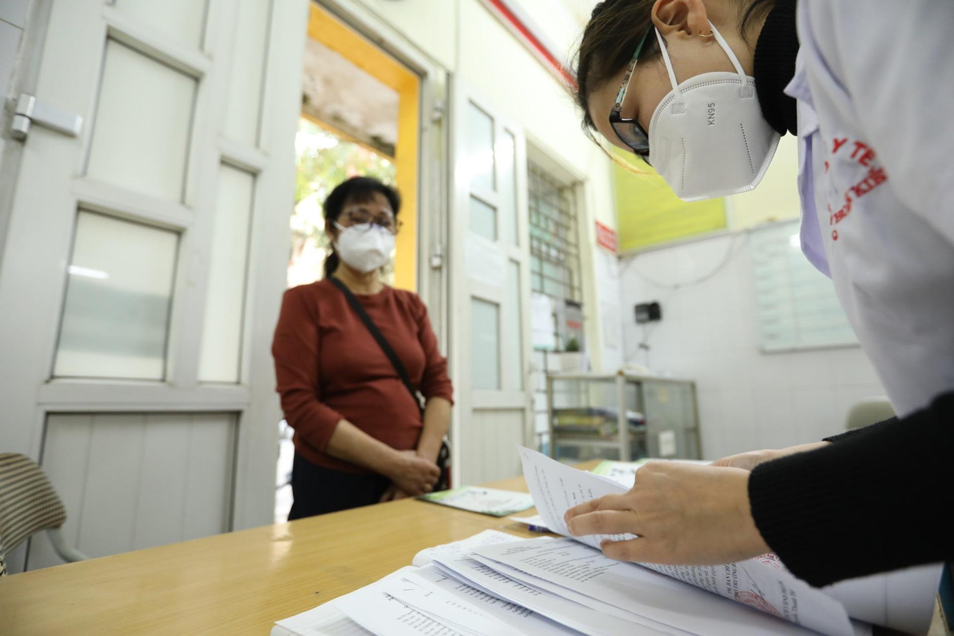 Trạm y tế phát giấy chứng nhận F0 khỏi bệnh cho đại diện tổ dân phố để trả cho từng hộ gia đình. Ảnh: Minh Quyết