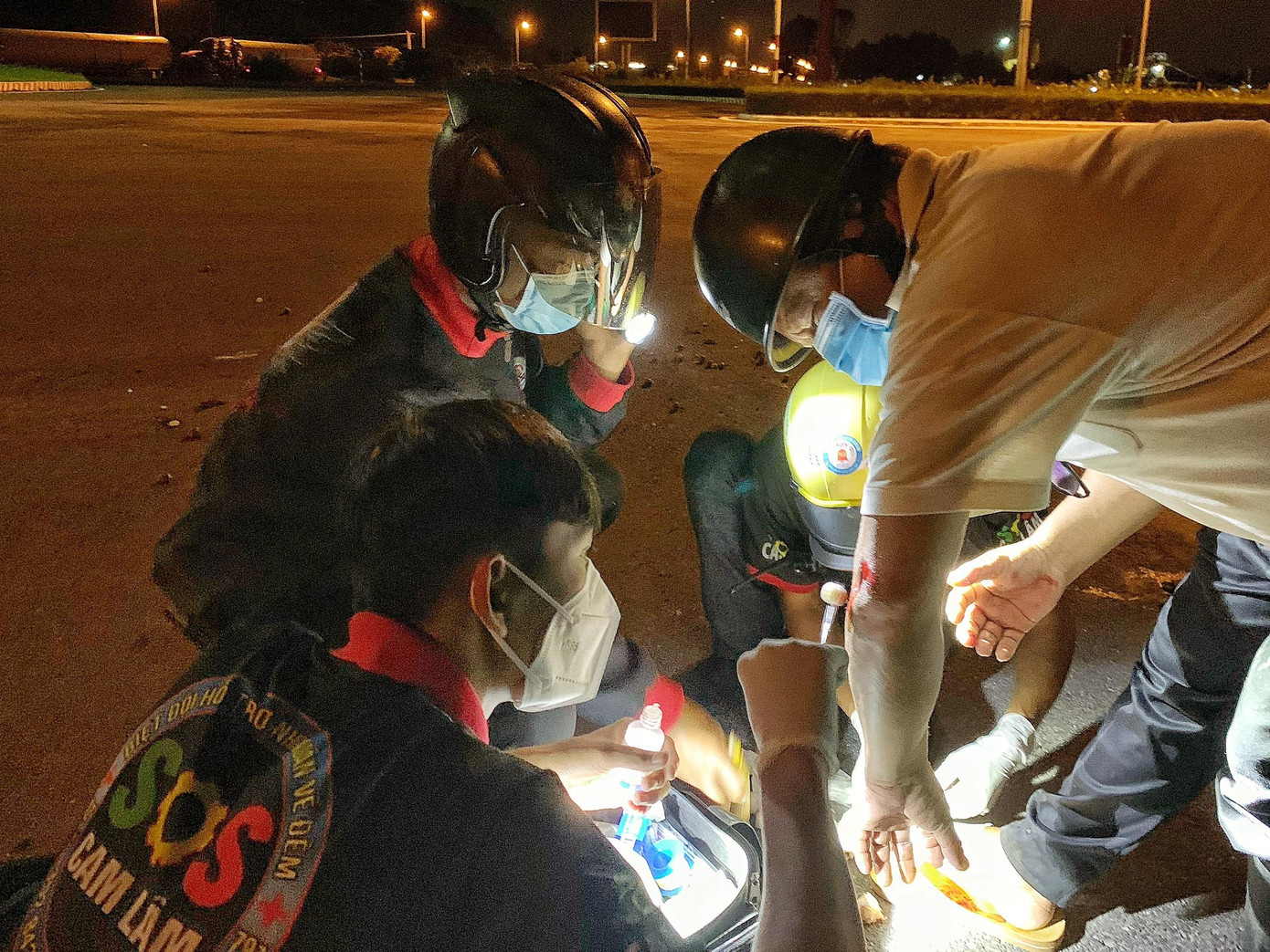 Các thành viên sơ cứu vết thương cho người đàn ông bị sụp ổ gà Các thành viên sơ cứu vết thương cho người đàn ông bị sụp ổ gà