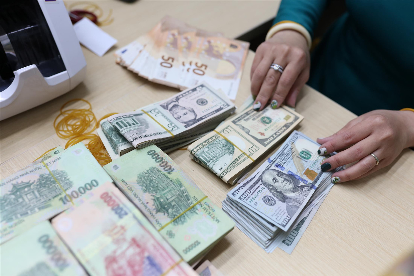 Việc Fed tăng lãi suất sẽ khiến đồng USD lên giá so với hầu hết các đồng tiền khác, tạo sức ép lớn hơn lên tỷ giá USD/VND. Minh hoạ: Như Ý