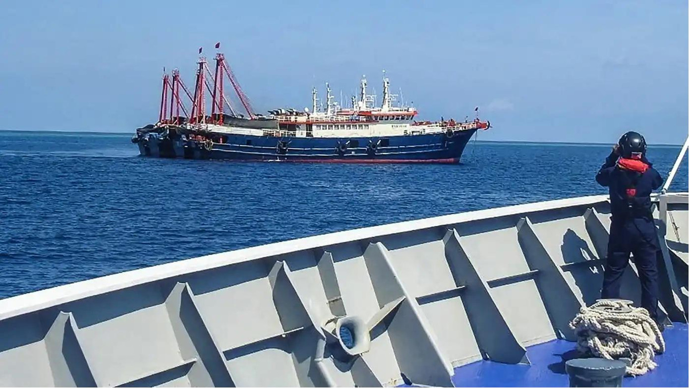 Tàu cảnh sát biển Philippines đang theo dõi một tàu Trung Quốc thả neo ngoài xa trên Biển Đông hồi tháng 4/2021. Ảnh: Jiji Tàu cảnh sát biển Philippines đang theo dõi một tàu Trung Quốc thả neo ngoài xa trên Biển Đông hồi tháng 4/2021. Ảnh: Jiji