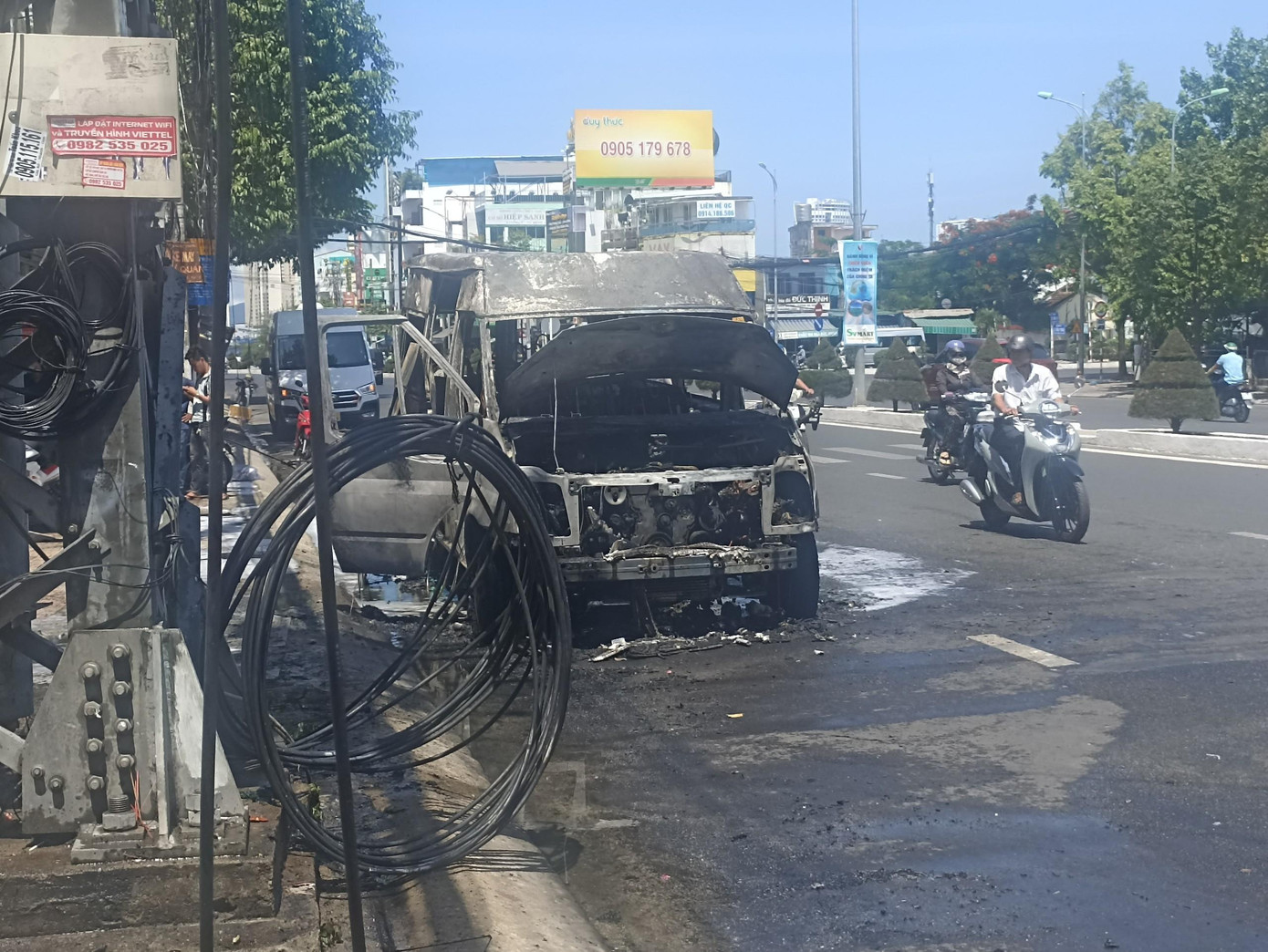 Đường dây điện tại đường 23/10 bị ảnh hưởng khi chiếc xe bốc cháy. Ảnh T.H