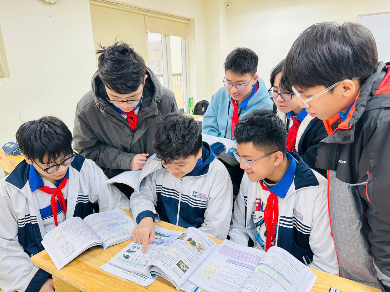 Phan Trung Hưng (ngồi thứ hai từ trái sang) chỉ bài khoa học cho các bạn. Ảnh: Cô Hà My cung cấp