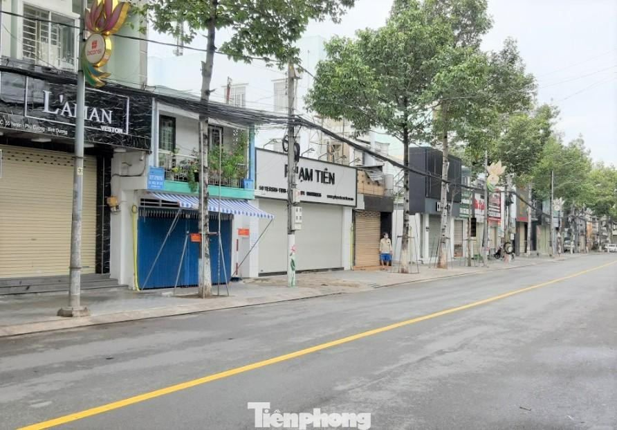 Hiện, chỉ có những doanh nghiệp đáp ứng điều kiện “3 tại chỗ” mới được hoạt động còn lại phải tạm ngưng để phòng, chống dịch bệnh. Bình Dương đã ban hành chính sách hỗ trợ người lao động ảnh hưởng bởi dịch bệnh. Trong ảnh: Phố phường vắng hoe ngày đầu giãn cách xã hội ở Bình Dương