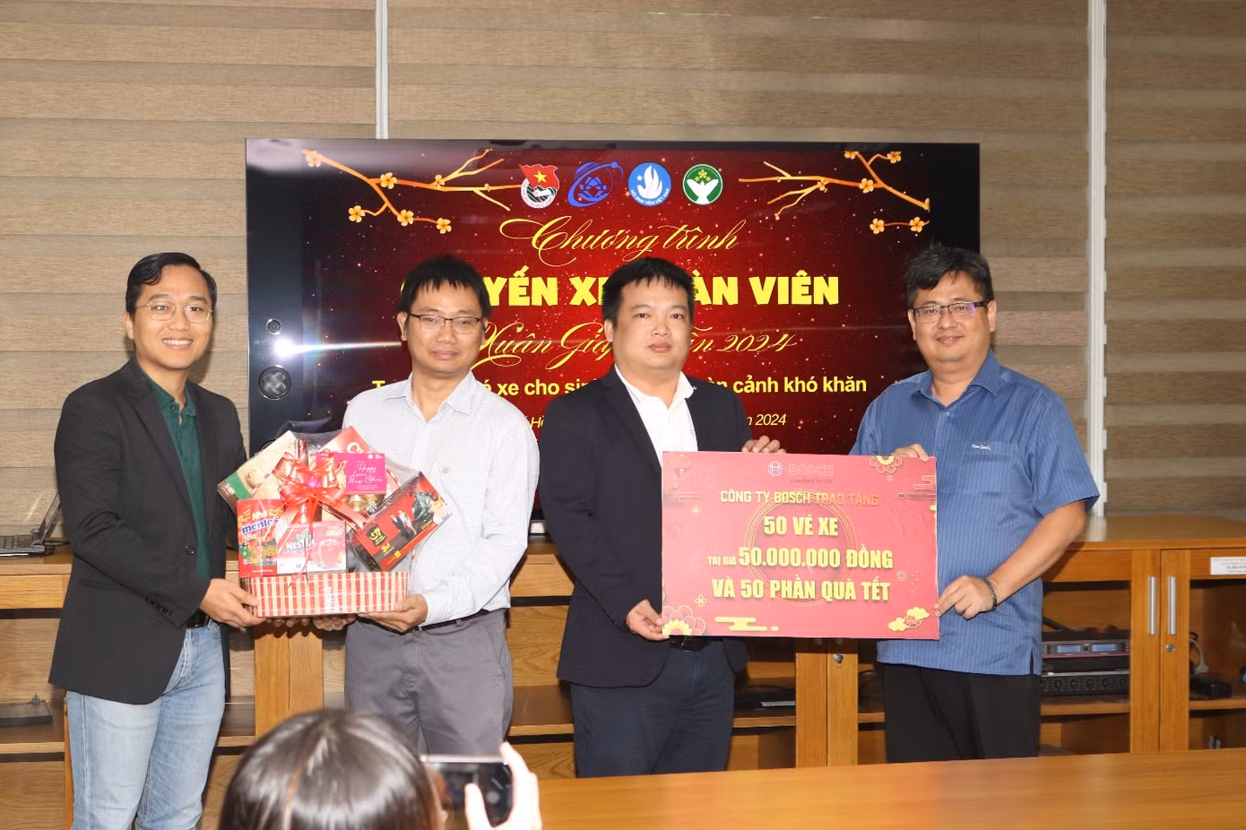 Đại diện công ty TNHH Bosch Global Software Technologies trao bảng tượng trưng tặng vé xe và quà tết cho sinh viên nhà trường.