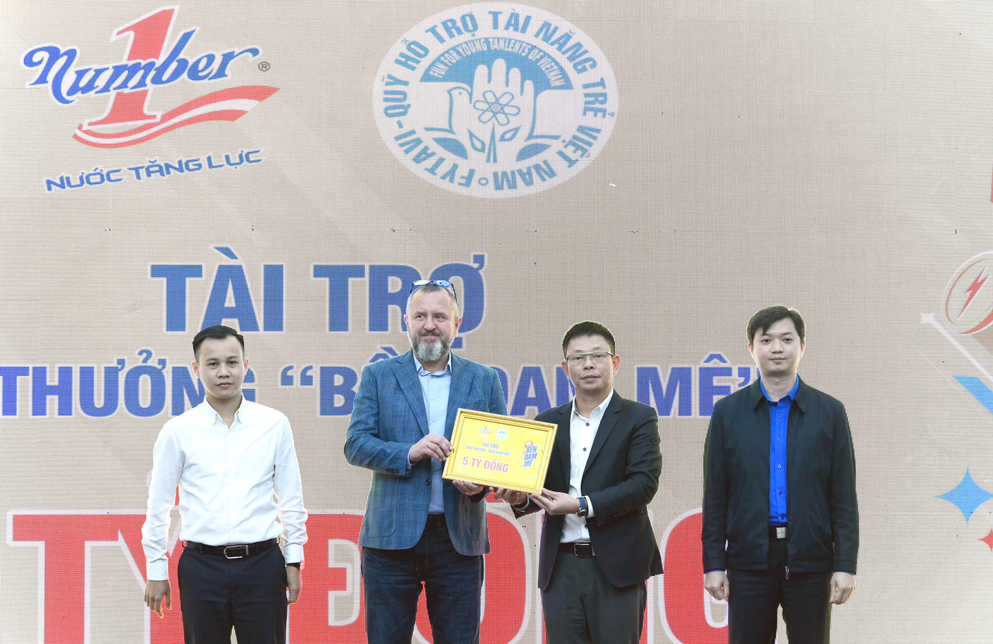 Ông Andrzej Tomasz Bialasiewicz - Tổng Giám đốc Marketing Công ty TNHH sản xuất thương mại dịch vụ Number One, trao biểu trưng tài trợ 5 tỷ đồng cho nhà báo Phùng Công Sưởng - Tổng Biên tập báo Tiền Phong, Giám đốc Trung tâm Quỹ Hỗ trợ Tài năng trẻ Việt Nam