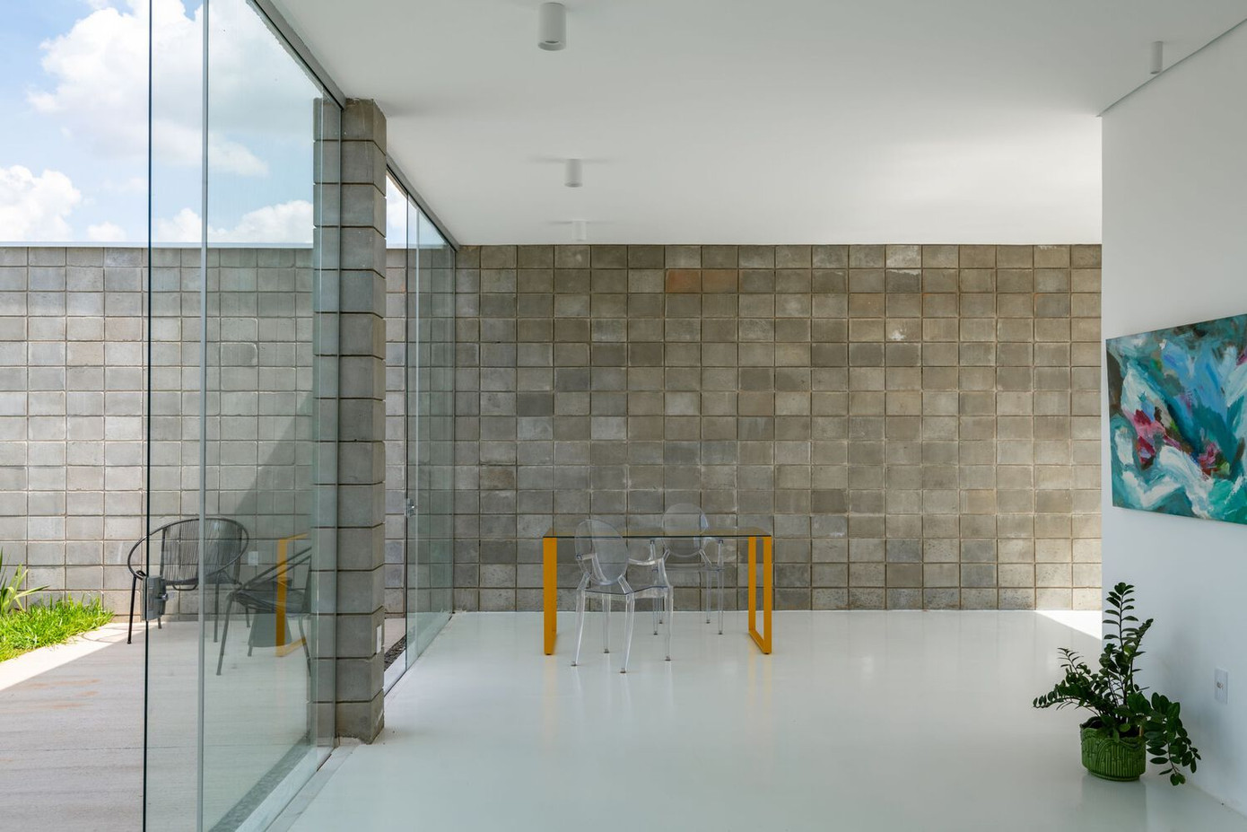 Ngôi nhà có bố cục mở và sử dụng tích hợp, được bao quanh bởi các tấm kính lớn.