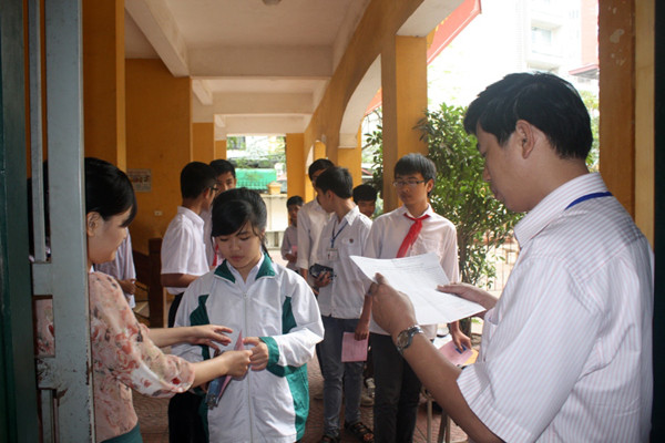 Các giám thị lần lượt đọc tên và kiểm tra thẻ dự thi của từng thí sinh