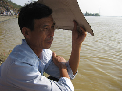 Ông Lực đau đớn ngồi bên bờ sông khi chưa tìm thấy thi thể của con trai. Ảnh: Phan Sáng ông Lực đau đớn ngồi bên bờ sông khi chưa tìm thấy thi thể của con trai.