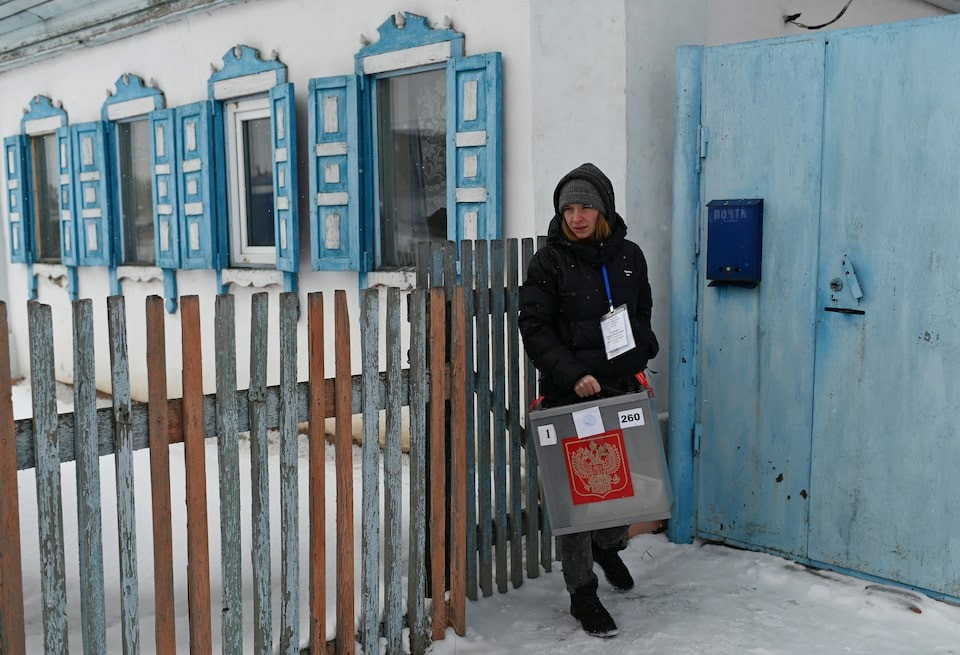 Một nhân viên bầu cử cầm hòm phiếu di động ở Omsk (Nga). Ảnh: Reuters