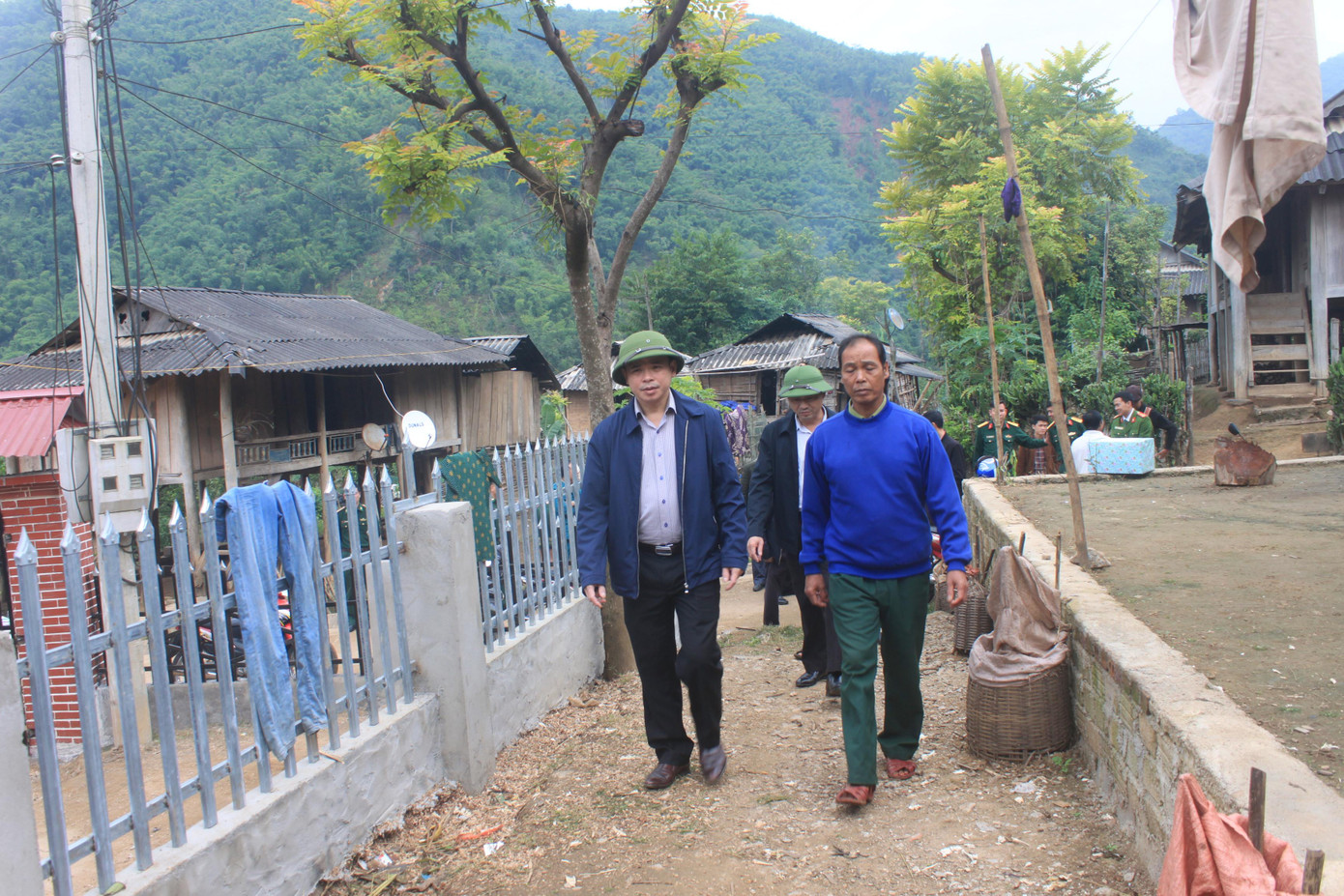 Bí thư Huyện uỷ Mường Lát (trái ảnh) Hà Văn Ca thăm hỏi đời sống đồng bào Khơ Mú ở khu phố Đoàn Kết.