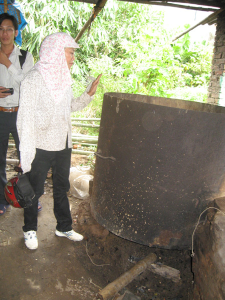 Bà Gấm đang giải thích quy trình sấy của lò sấy dược liệu