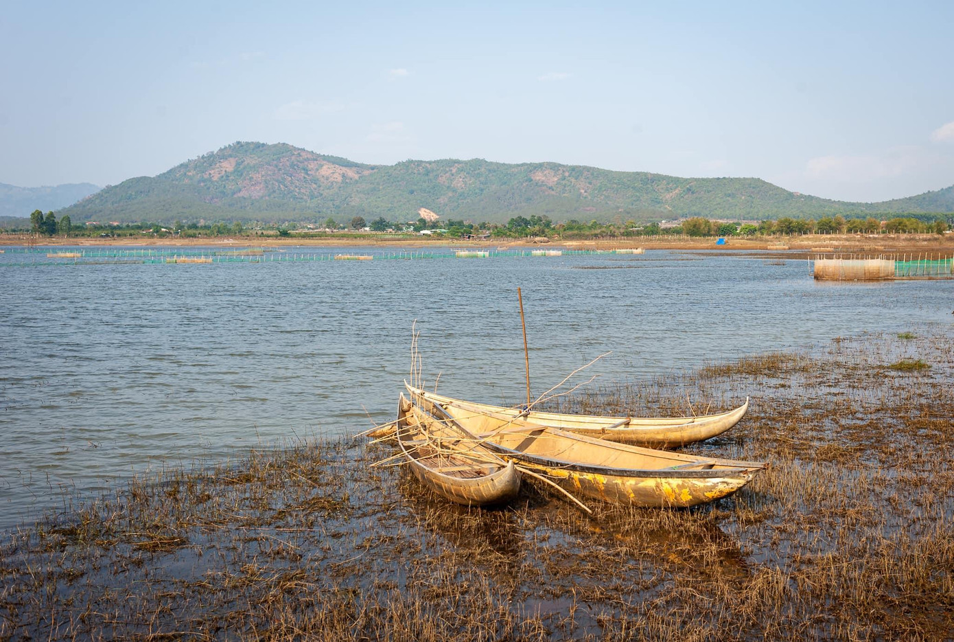 Những con thuyền độc mộc nằm lặng lẽ bên hồ - Ảnh: Pi Phạm Những con thuyền độc mộc nằm lặng lẽ bên hồ - Ảnh: Pi Phạm