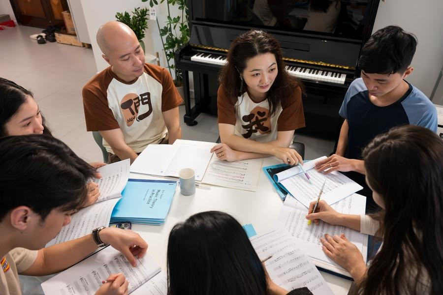 Vợ chồng Đồng Quang Vinh - Mạc Song Song làm việc với dàn nhạc của mình. (Ảnh: Tân Hoa Xã)