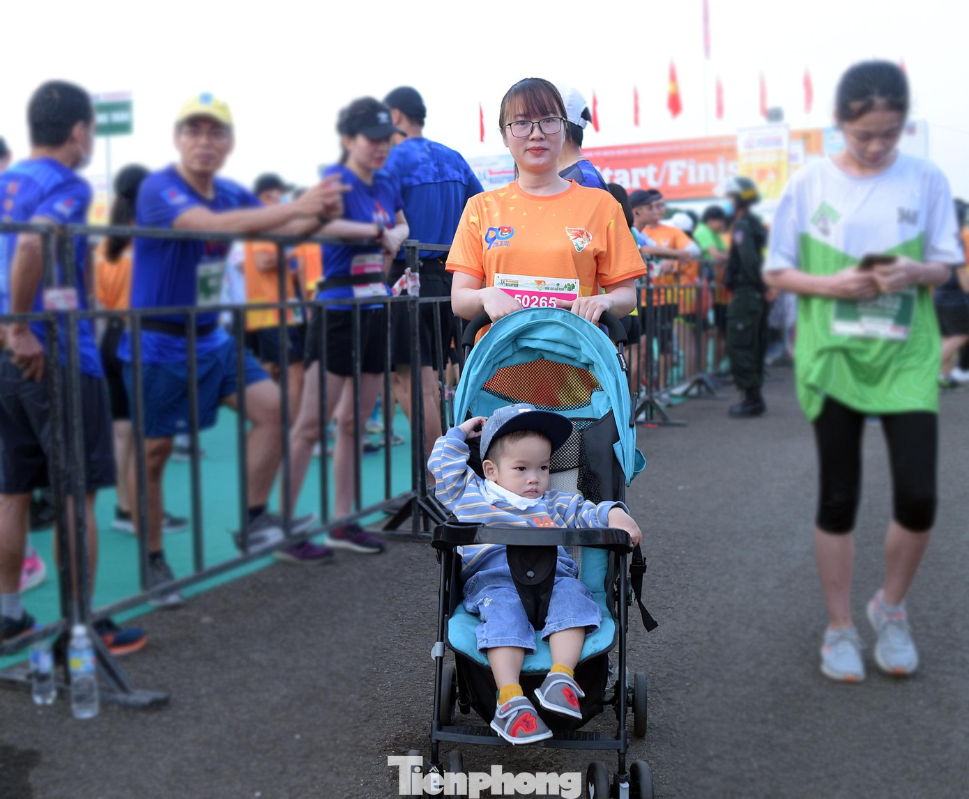 Chị Linh và con trai 20 tháng tuổi chuẩn bị bước vào đường đua 5km. Ảnh: Xuân Tùng