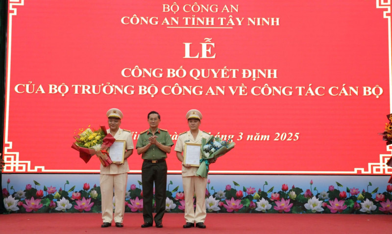 Đại tá Nguyễn Văn Trãi trao quyết định và tặng hoa cho hai tân Phó Giám đốc Công an tỉnh Tây Ninh. Ảnh: CAND.
