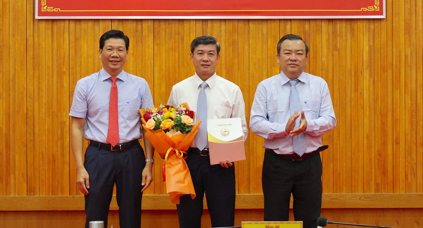 Ông Trương Văn Hoàn (giữa), nhận quyết định và hoa chúc mừng của lãnh đạo tỉnh Tây Ninh. Ảnh: BTN